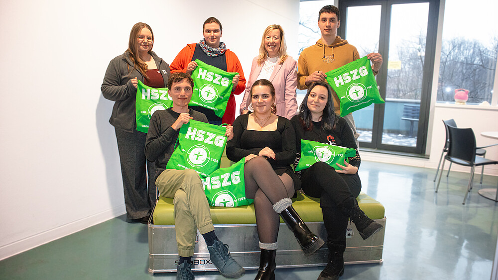 Beteiligte am CampusKompass-Projekt und die Prorektorin halten grüne HSZG-Beutel in die Höhe.
