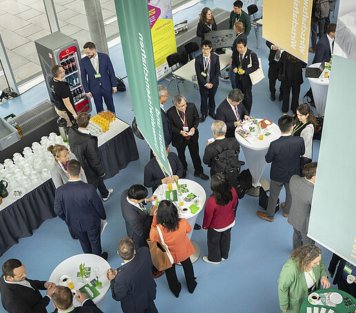 Vogelperspektive auf das Networking während der Kaffeepause im Foyer mit verschiedenen Gesprächsgruppen.