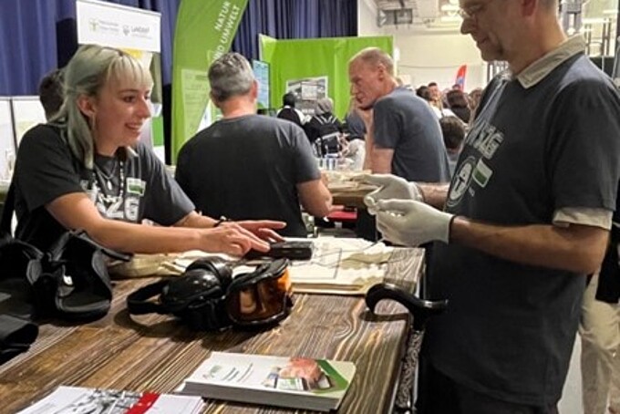 Eine Mitarbeiterin berät einen Besucher am GAT-Stand.