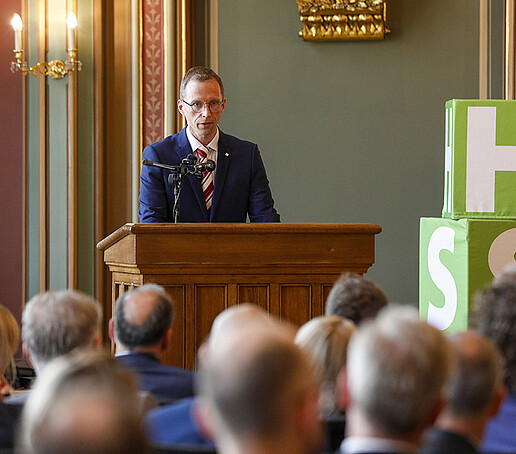 Prof. Kornhuber hält am Rednerpult ein Grußwort.