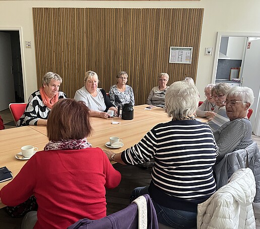 Viele ältere Damen sitzen am Tisch und unterhalten sich