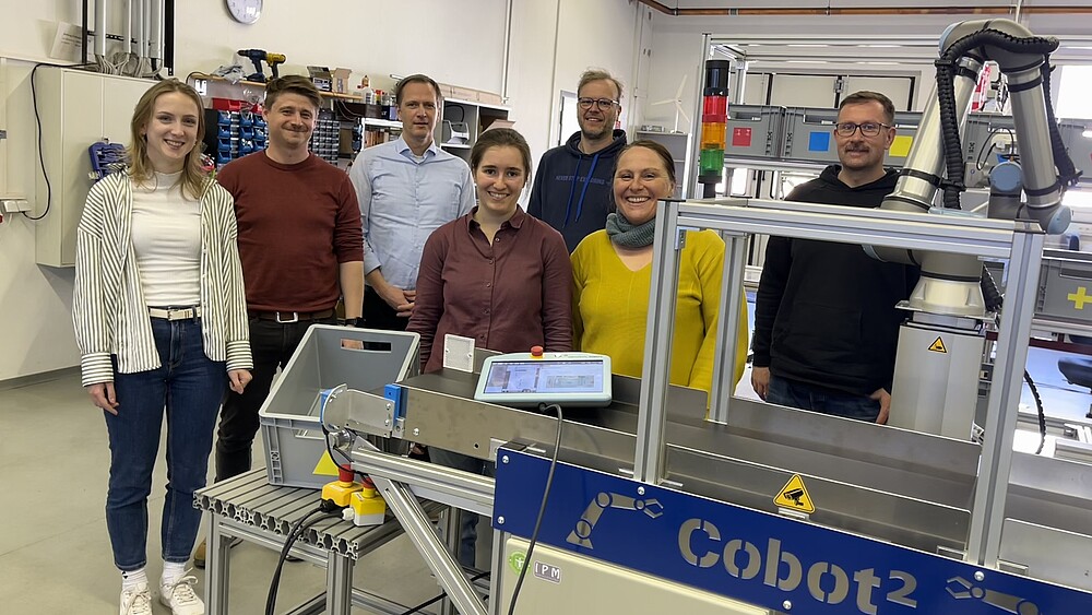 Projektbeteigte Menschen vor der Cobot-Anlage