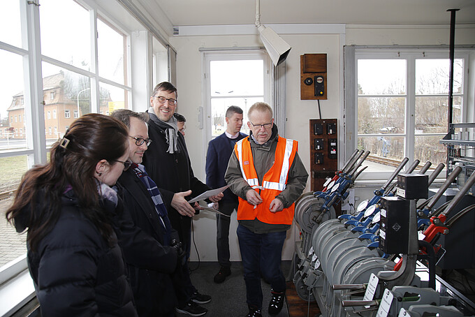 Volker Brade erklärt dem Besuch der FH Erfurt und dem Rektor das Prinzip der Weichenstellung.