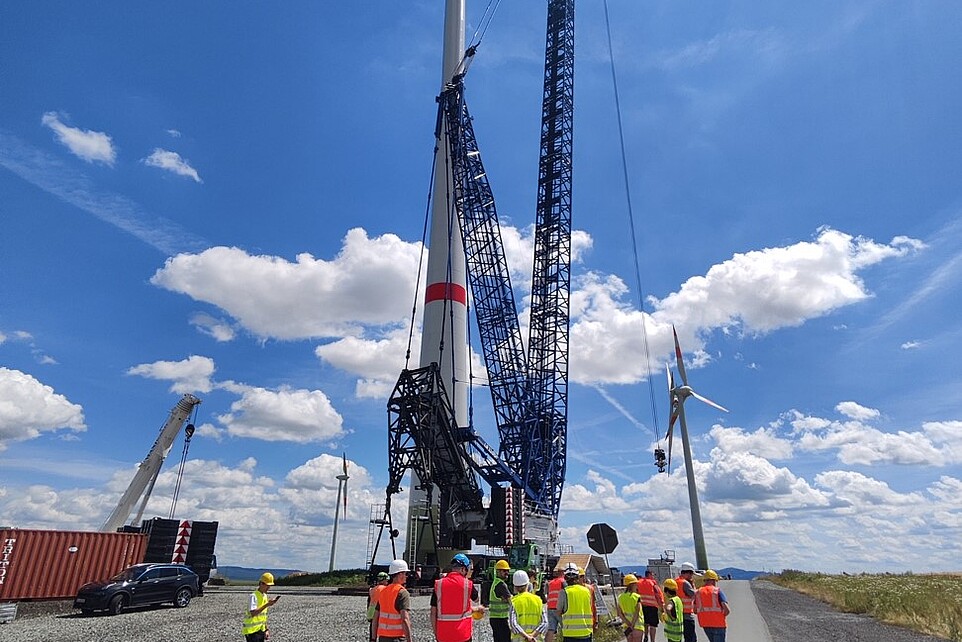 Eine Gruppe von Menschen mit auf einem Feld an an großem Kran