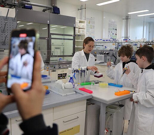 Zwei Schüler an der Pipettierstation im Labor arbeiten mit Pipetten.
