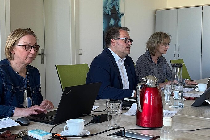 Mitglieder der Personalentwicklungskommission sitzen an Konferenztischen im Senatssaal der HSZG und besprechen sich. An der Stirnseite sitzt der Rektor.