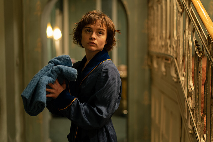 Eine Dartstellerin aus Franky-Five-Star im Bademantel und mit Handtuch