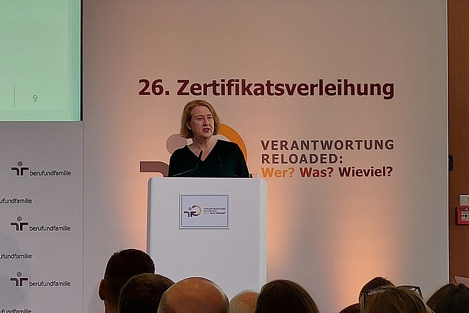 Die Bundesministerin für Familie steht auf der Bühne am Rednerpult und hält eine Rede.