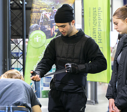 Ein Studieninteressierter zieht den Altersimulationsanzug an.