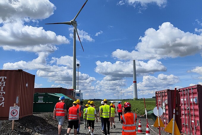 Eine Gruppe von Menschen mit auf einem Feld an Baucontainern