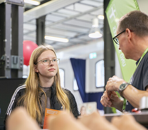 Eine Studieninteressierte informiert sich am Stand für Angewandte Pflegewissenschaft.