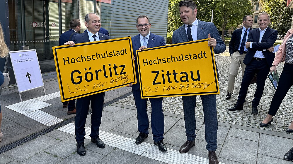 Ursu, Kratzsch und Zenker mit den Ortseingangsschildern in den Händen