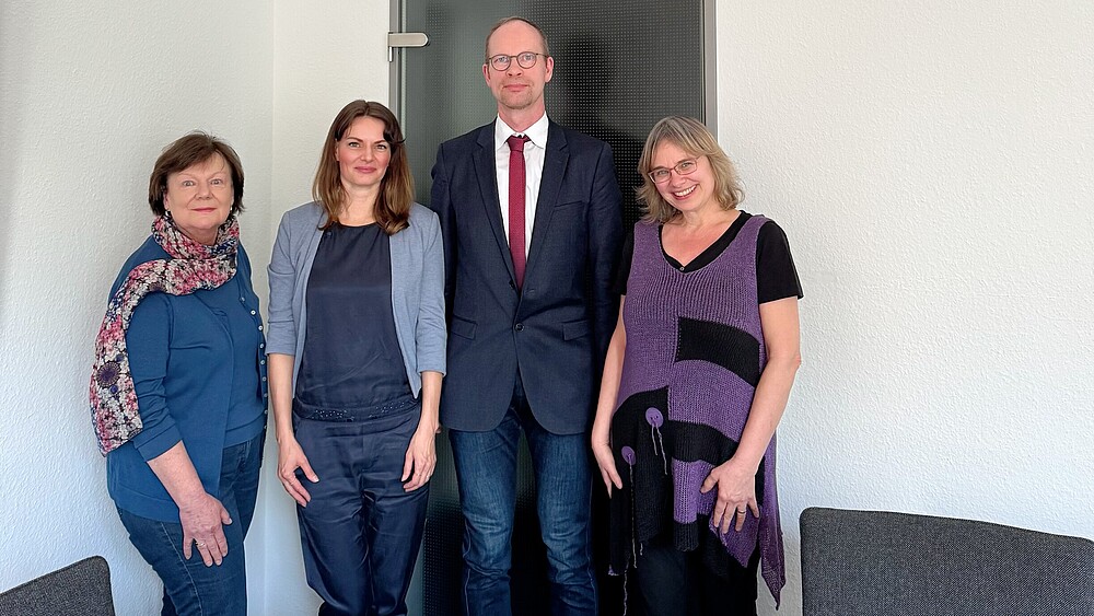 Vier Personen haben sich zum Bild formiert