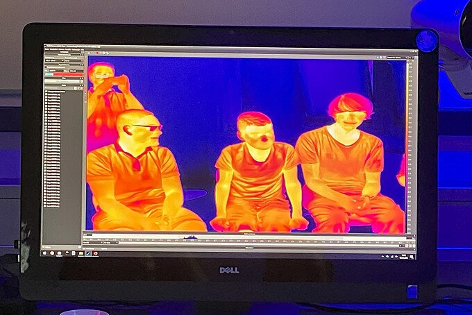 Auf einem Wärmebildkamerabild sind mehrere Menschen zu sehen.