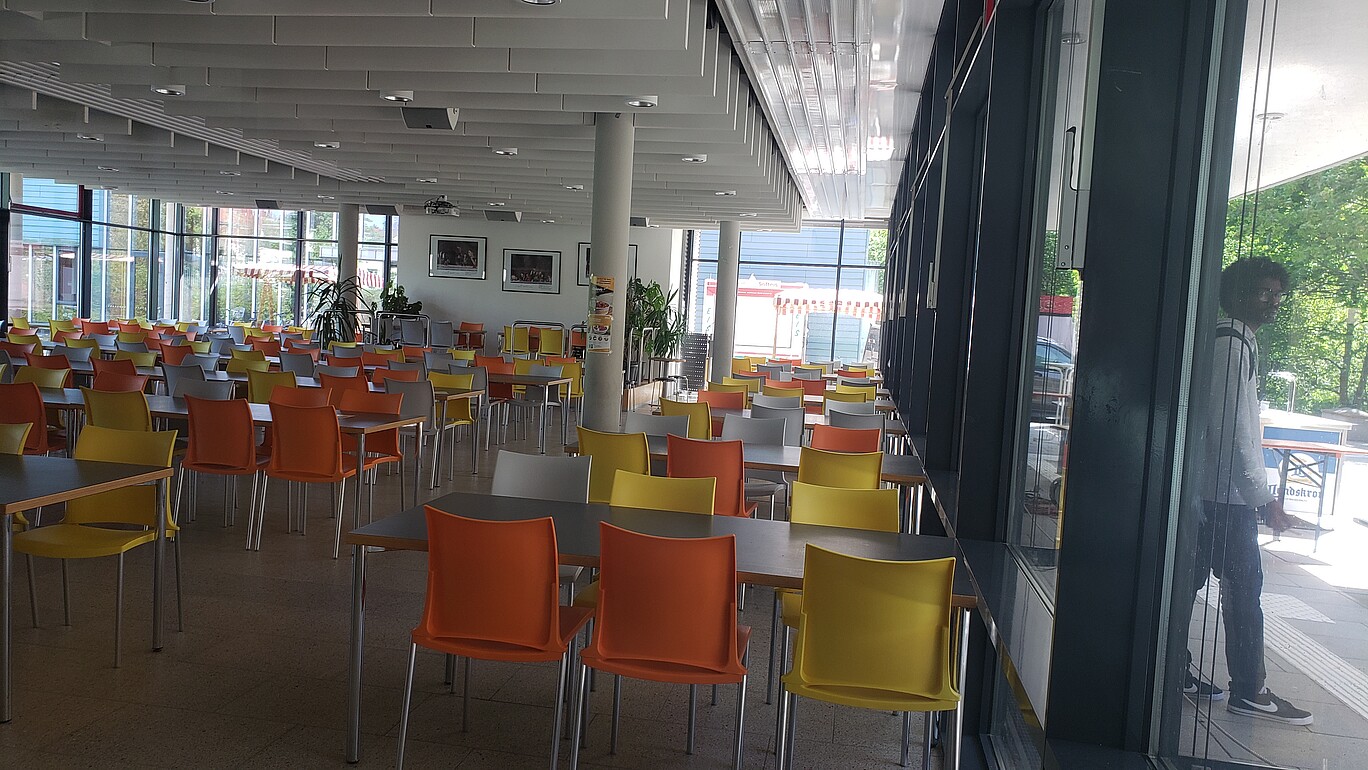Blick in die Mensa, viele leere Tische und Stühle