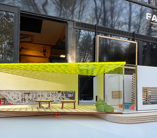 Ein Raummodell steht auf einem Tisch. Darin sind Sitzgelegenheiten und Abstellmöglichkeiten zu sehen.