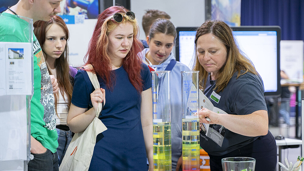 Interessierte schauen sich den Versuchsstand der Fakultät Natur- und Umweltwissenschaften an.