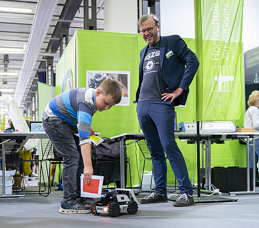 Ein Kind probiert einen Roboter aus.