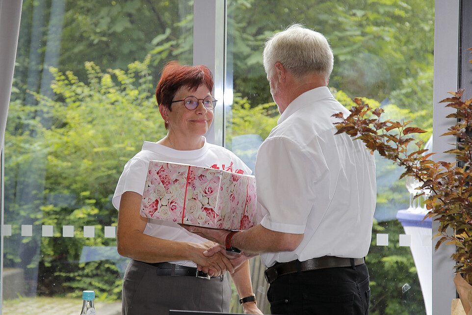 Frau Hollstein nimmt Glückwünsche und ein Geschenk entgegen.
