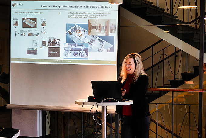 Prof. Dr. Sophia Keil steht am Stehtisch mit aufgeklappten Laptop und hält einen Vortrag.