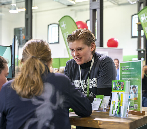 Eine HSZG-Praktikantin berät zwei Mädchen.