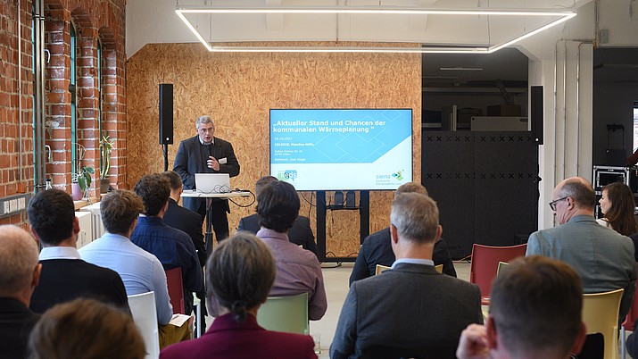 Uwe Kluge von der SAENA hält in einem Konferenzraum im Celsiuz einen Vortrag vor gut gefüllten Sitzreihen.