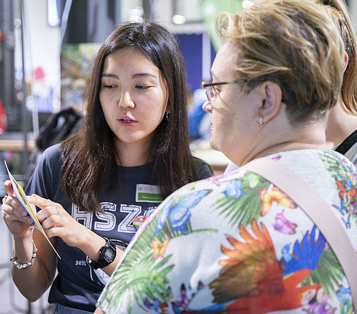 Eine HSZG-Mitarbeiterin im Gespräch mit einer Besucherin.