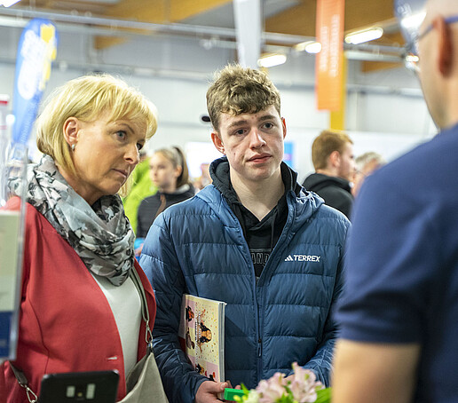 Mutter und Sohn lassen sich am KIA-Stand beraten.