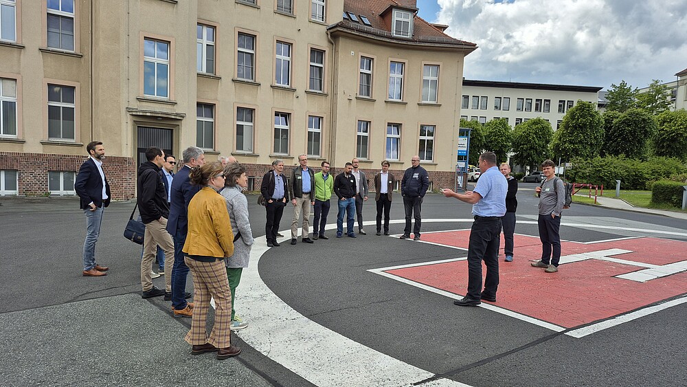 Eine Gruppe Menschen steht rund um den Helikopterlandeplatz vor dem Klinikum Zittau.