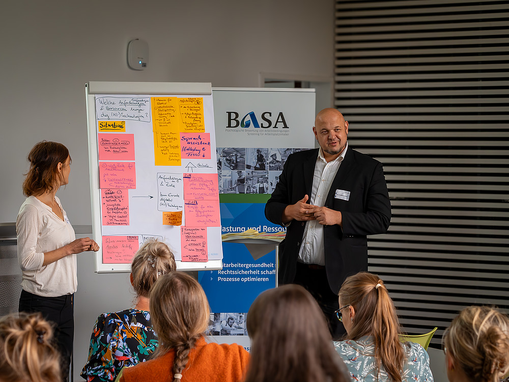 Prof. Schmidt zeigt die Ergebnisse des Workshops auf einem Flipchart
