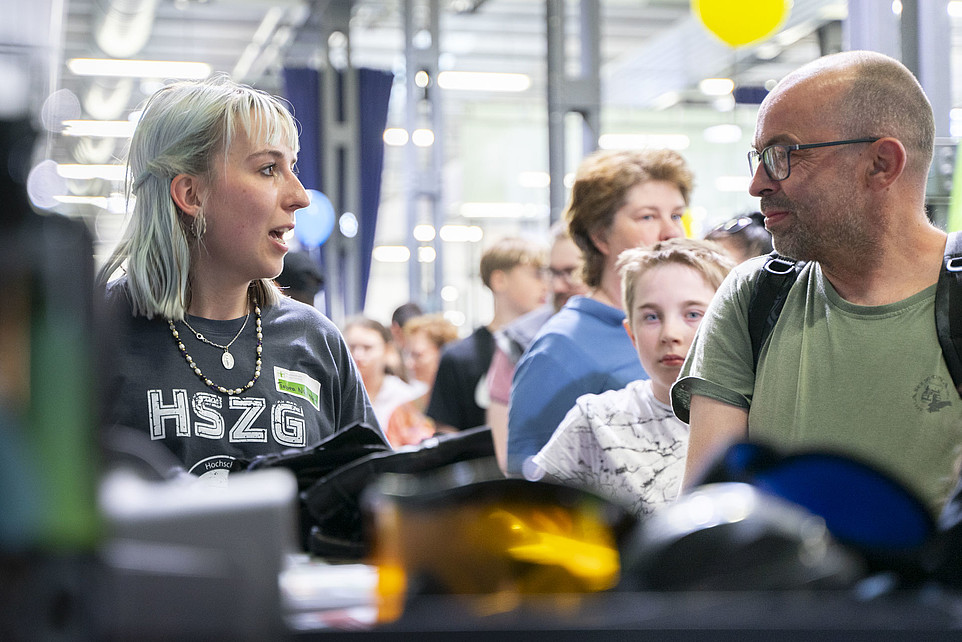 Eine Mitarbeiterin berät einen Besucher am GAT-Stand.