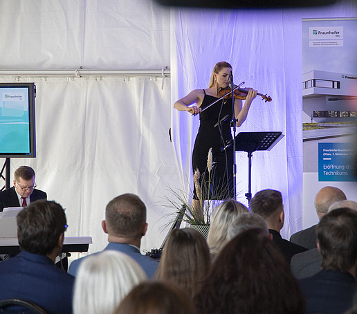 Eine Violinistin spielt auf der Bühne vor Publikum.