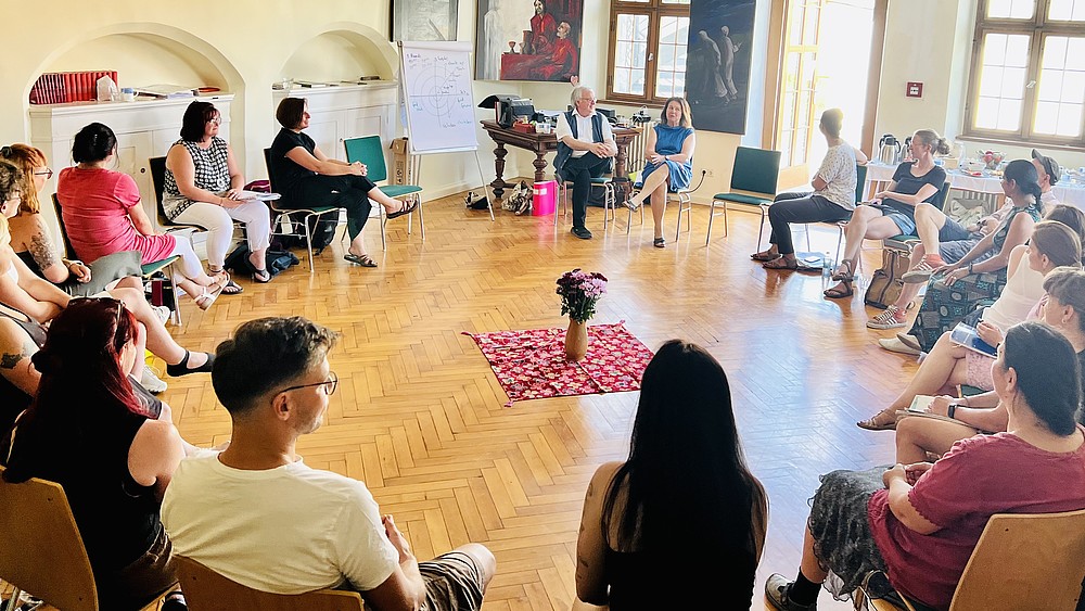 In einem Stuhlkreis diskutieren Teilnehmende eines Kurses zur systemischen Ausbildung.