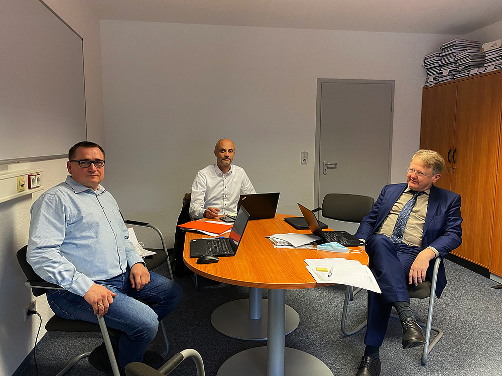 drei Männer an einem Tisch