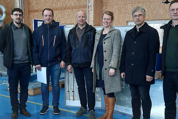 HSZG- und Firma Härtwig Maschinenbau GmbH-Mitarbeitende stehen zum Gruppenfoto in der Landerhalle nebeneinander und lächeln in die Kamera.