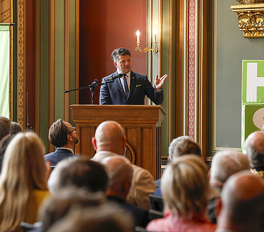 Der Oberbürgermeister Zenker steht am Rednerpult und hält ein Grußwort.