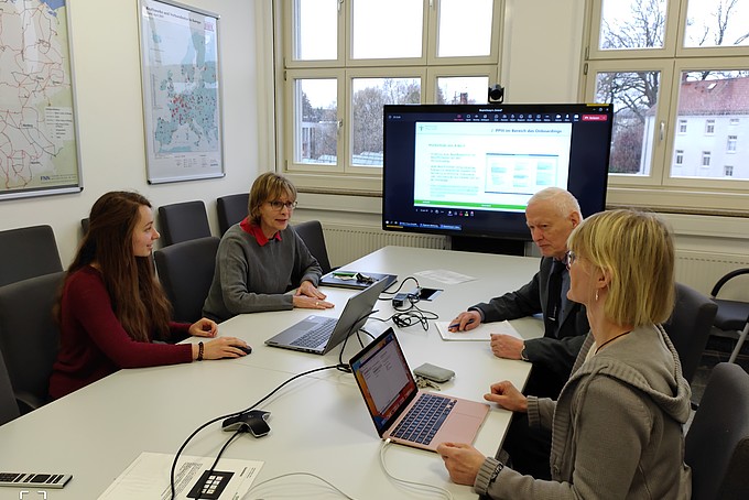 Im Beratungssaal sitzt Maren Molch mit DPR-Vertreter*innen in einer Sitzung.