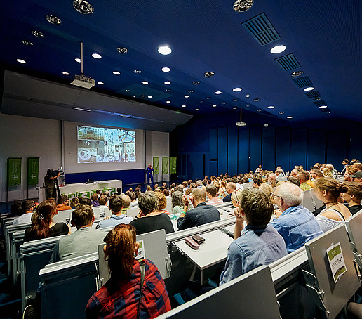 Vollbesetzte Sitzreihen im Hörsaal