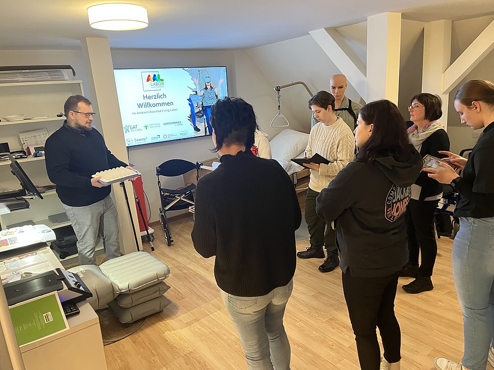 Person stellt smarte Medikamentenbox einer Personengruppe vor