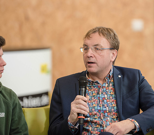 Prof. Kroschel mit Mikro auf dem Talk-Sofa