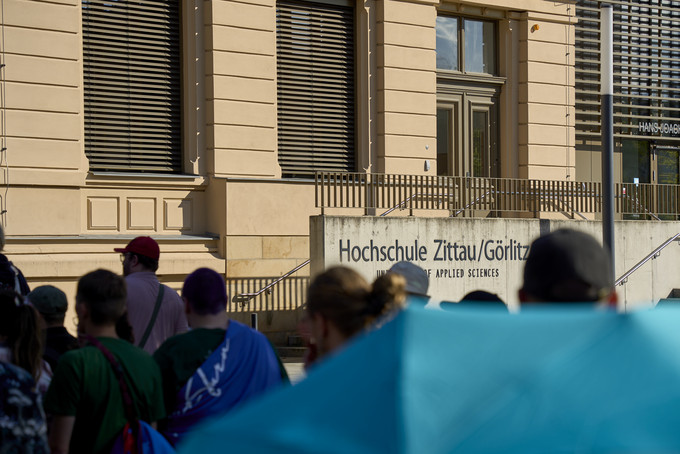 Am Zittauer Stadtring ziehen CSD-Teilnehmende am Hochschulhaus Nummer eins vorbei.