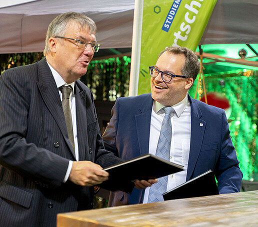 Prof. Hänsel und der Rektor lachen sich an nach der Kooperationsvereinbarung.