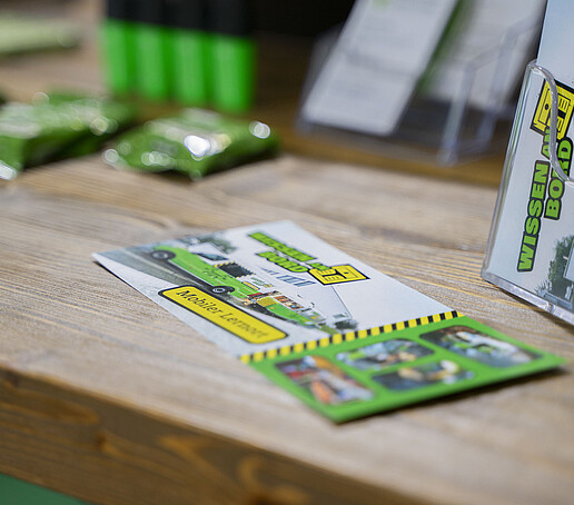 Ein Airstream-Flyer liegt auf einem Tisch, rechts daneben der Flyerständer.