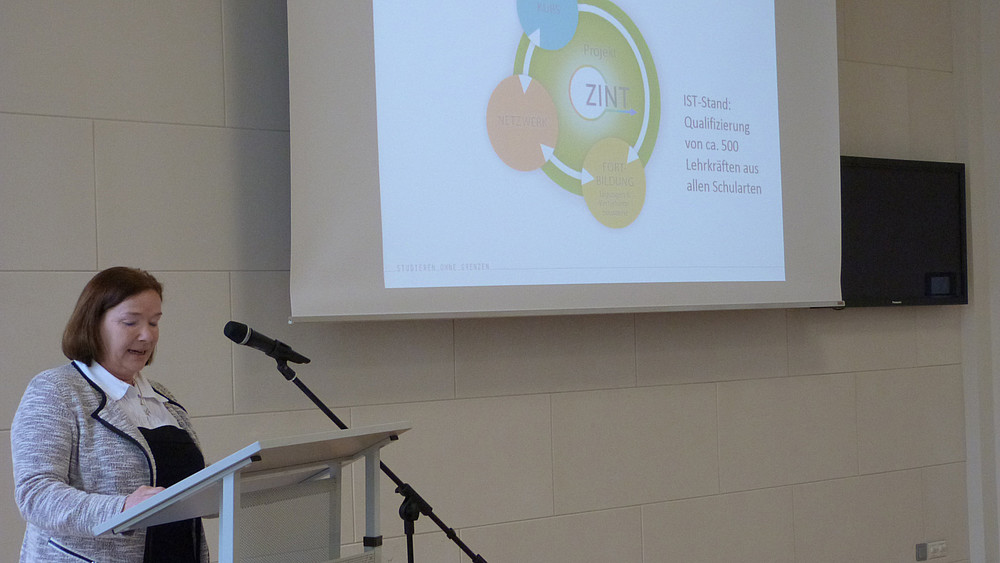 Frau steht am Pult und hält einen Vortrag