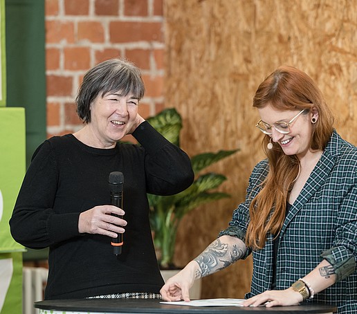 Moderatorin und Studio-Gast lachen im Live-Studio.