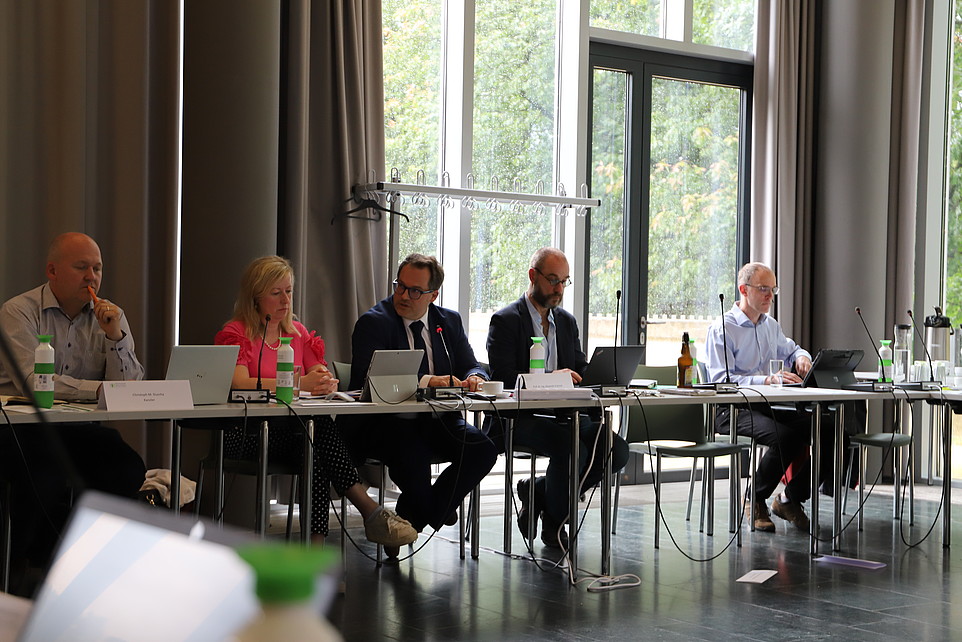 Das Rektorat sitzt an einem langen Tisch in der Aula.