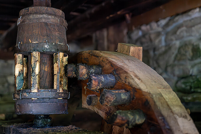 Eine Wassermühle, geprägt von Materialspuren und angedeuteter Bewegung.