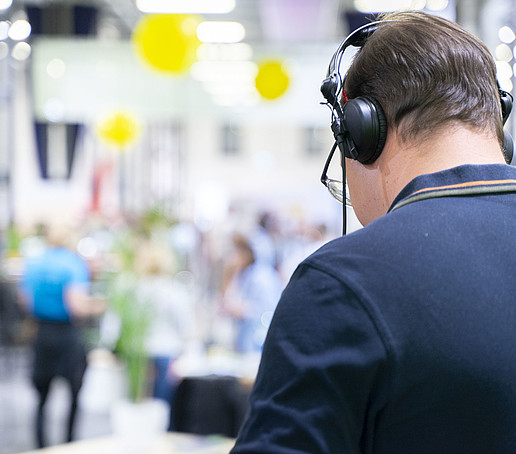 Der DJ mit Kopfhörern schaut auf seinen Plattentable.
