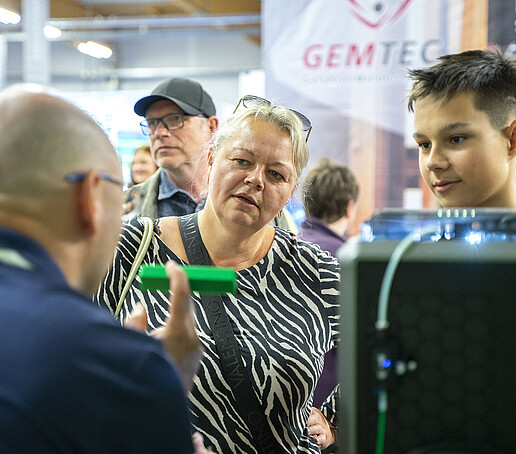 Mutter und Sohn lassen sich am KIA-Stand beraten.
