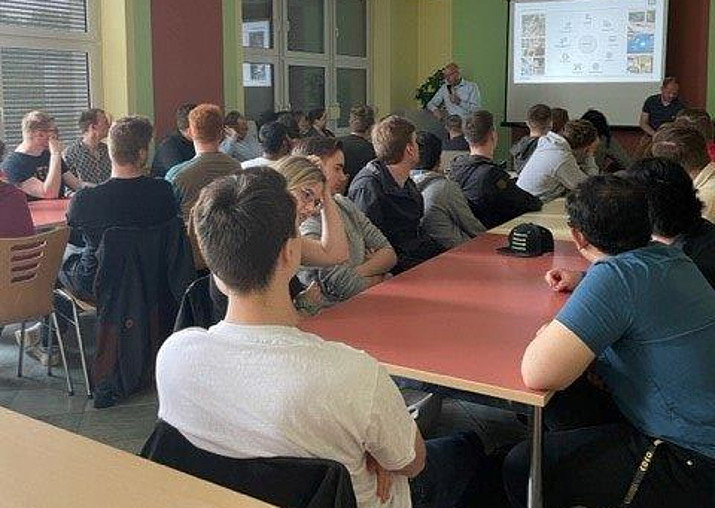 Im MBN-Aufenthaltsraum sitzen die Exkursionsteilnehmenden und lauschen einem Vortrag.